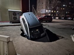 Иномарка провалилась под асфальт на стоянке